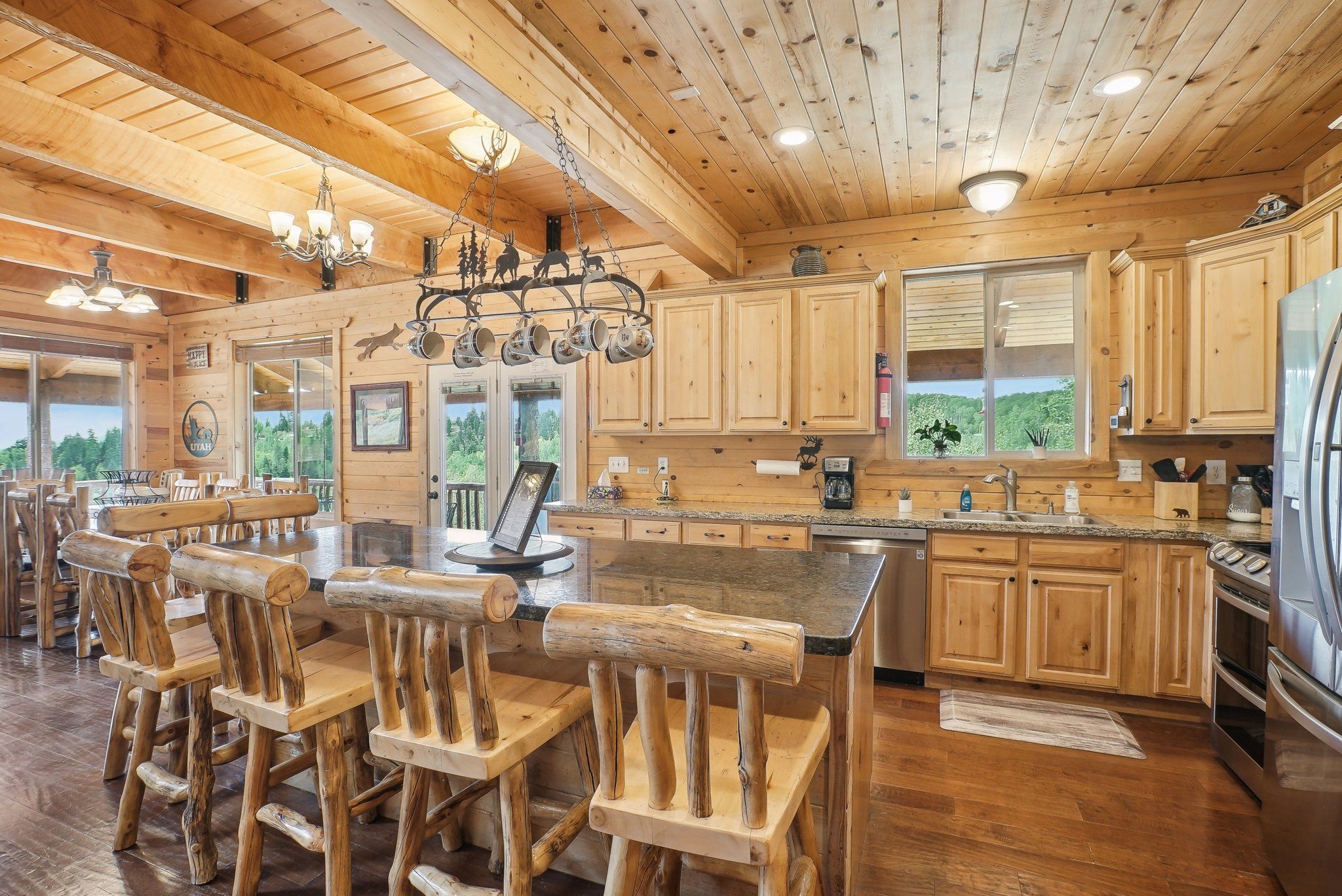 Large wood kitchen with granite island, double oven, and group dining area