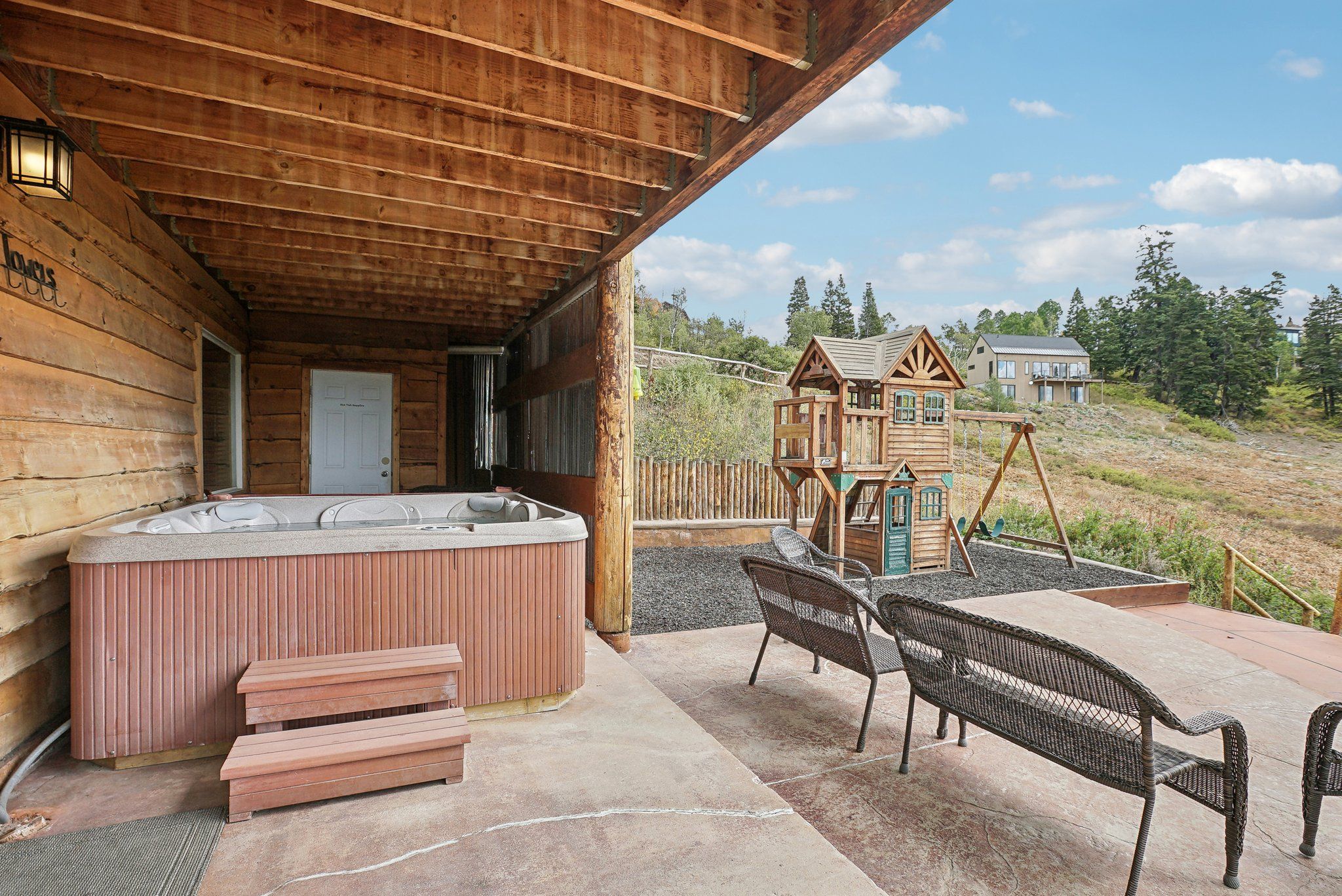 Private hot tub on the lower patio with the playground beyond