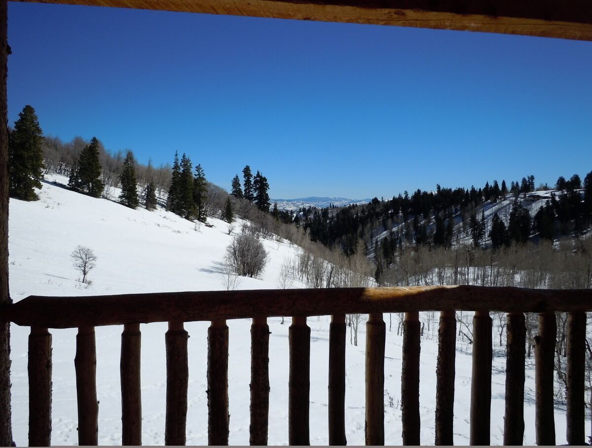 Snow-covered Tollgate Canyon hillside seen from the lodge deck